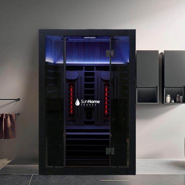 Modern black sauna with purple LED lighting in a sleek room.