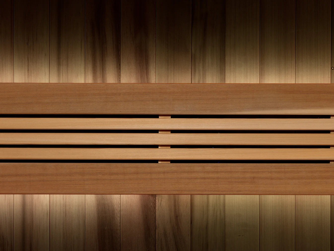 Wooden sauna bench with warm lighting and curtains.