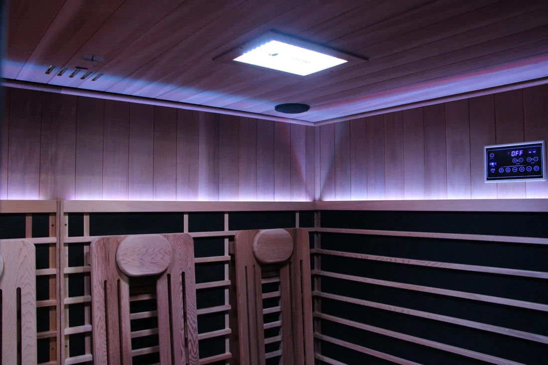 Interior of a modern wooden sauna with lighting and seating.