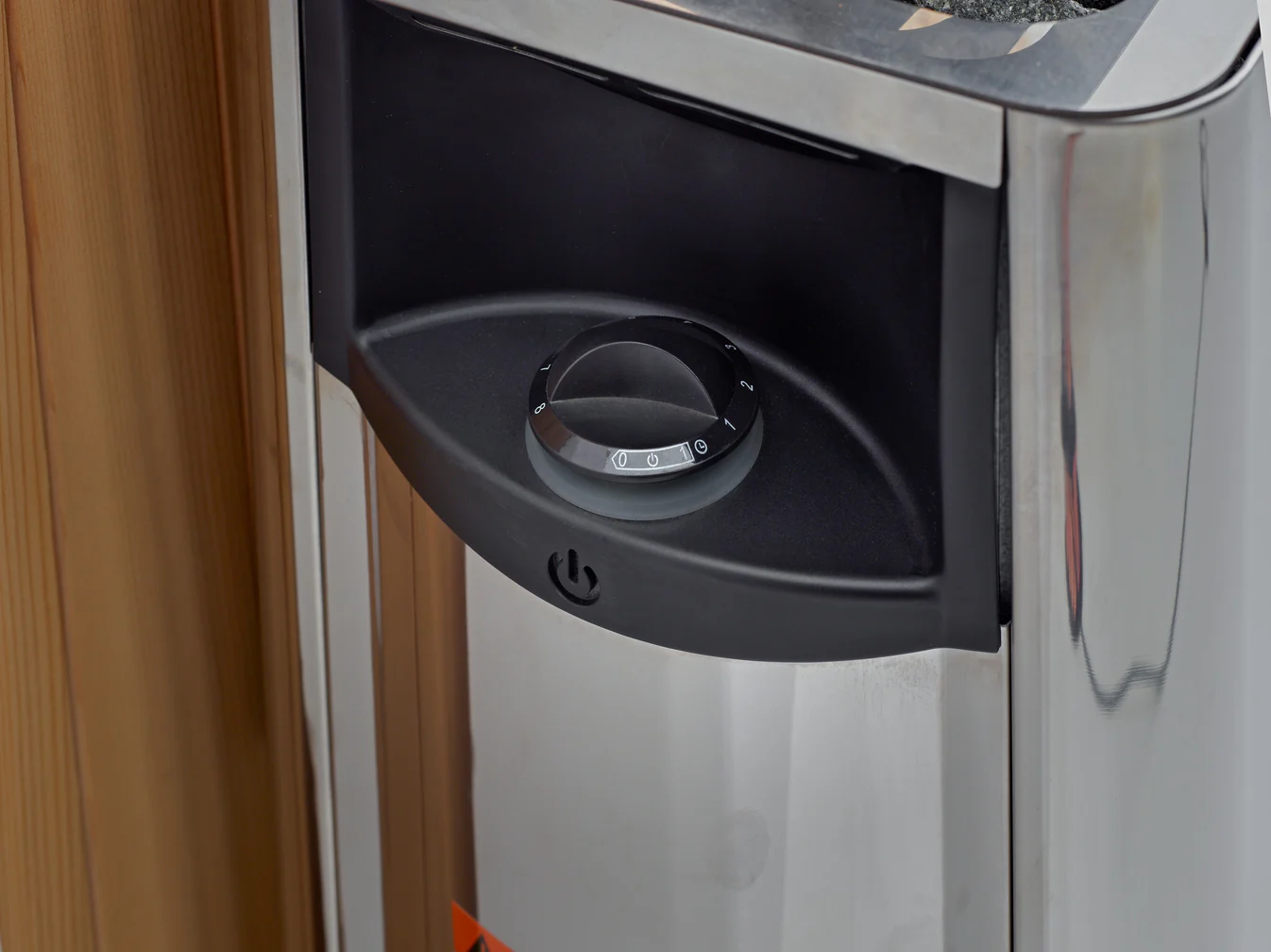 Close-up of a black control knob on a metallic appliance.