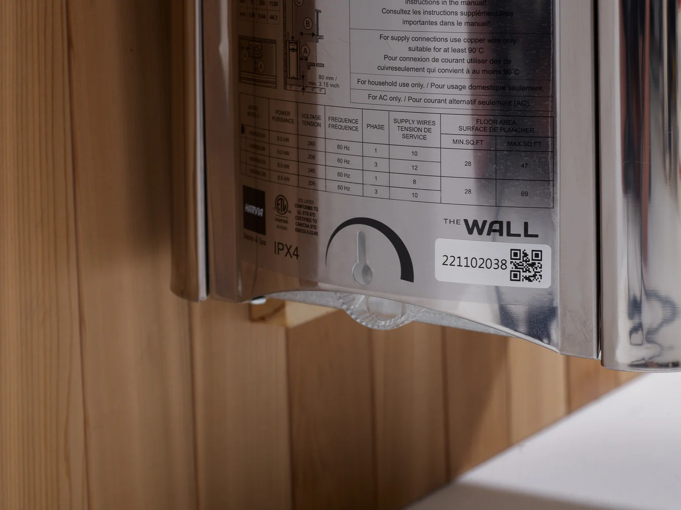 A close-up of a wall-mounted device with a QR code and instructions.