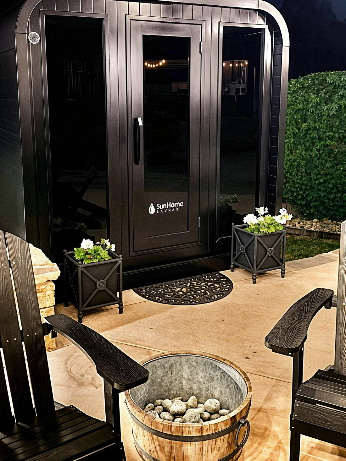 Cozy outdoor seating with firepit and plants by a black door.