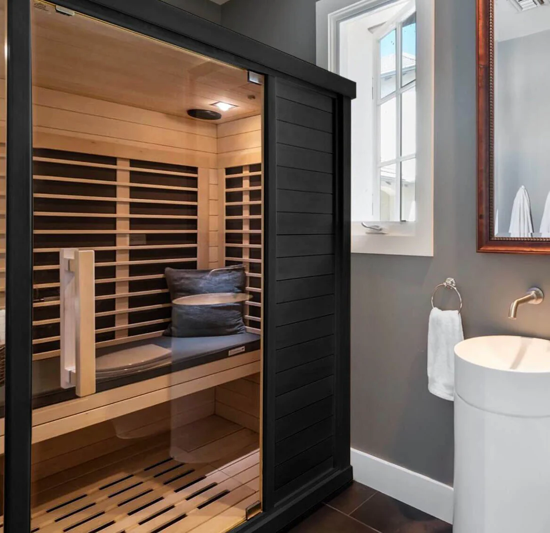 Modern home sauna with wooden interior and sleek glass door.