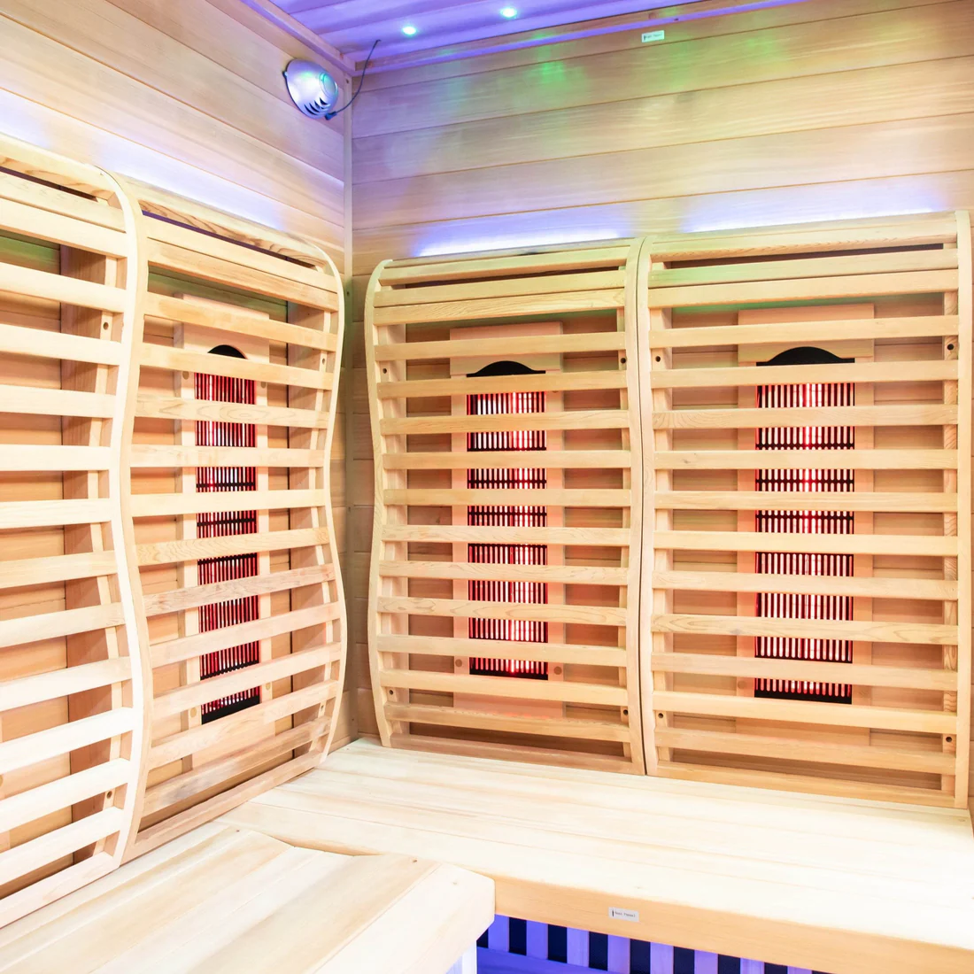 Interior of a wooden sauna with warm lighting and heating panels.