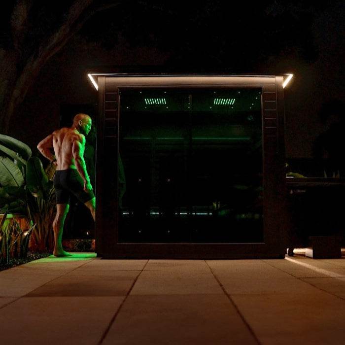 Person cleaning floor at night with a mop near plants.