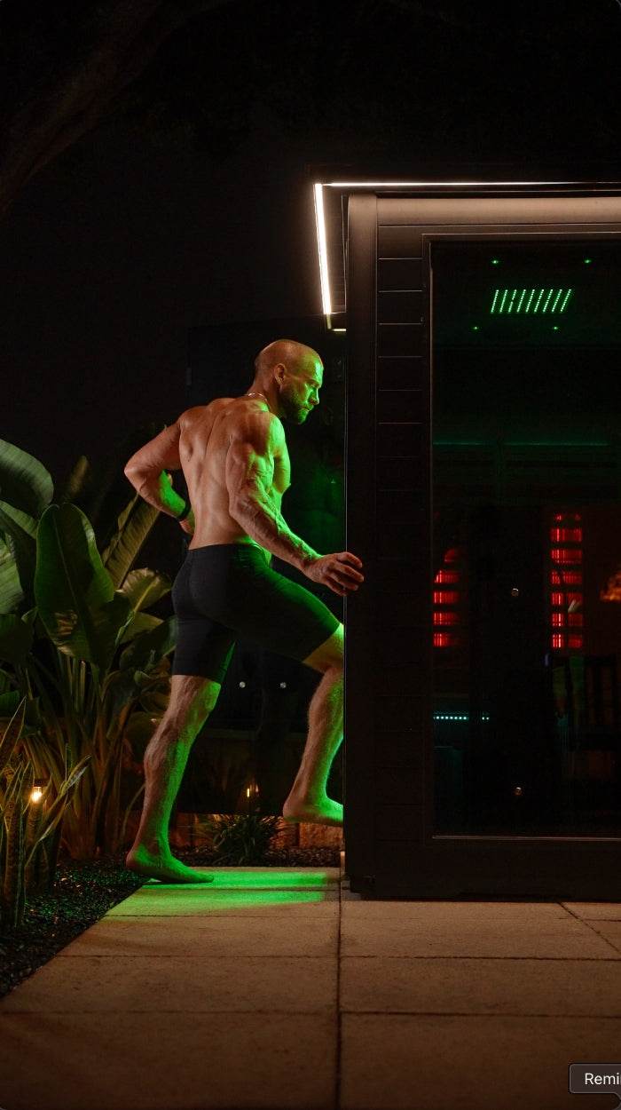 A muscular man climbing stairs in a dimly lit gym with green lighting.