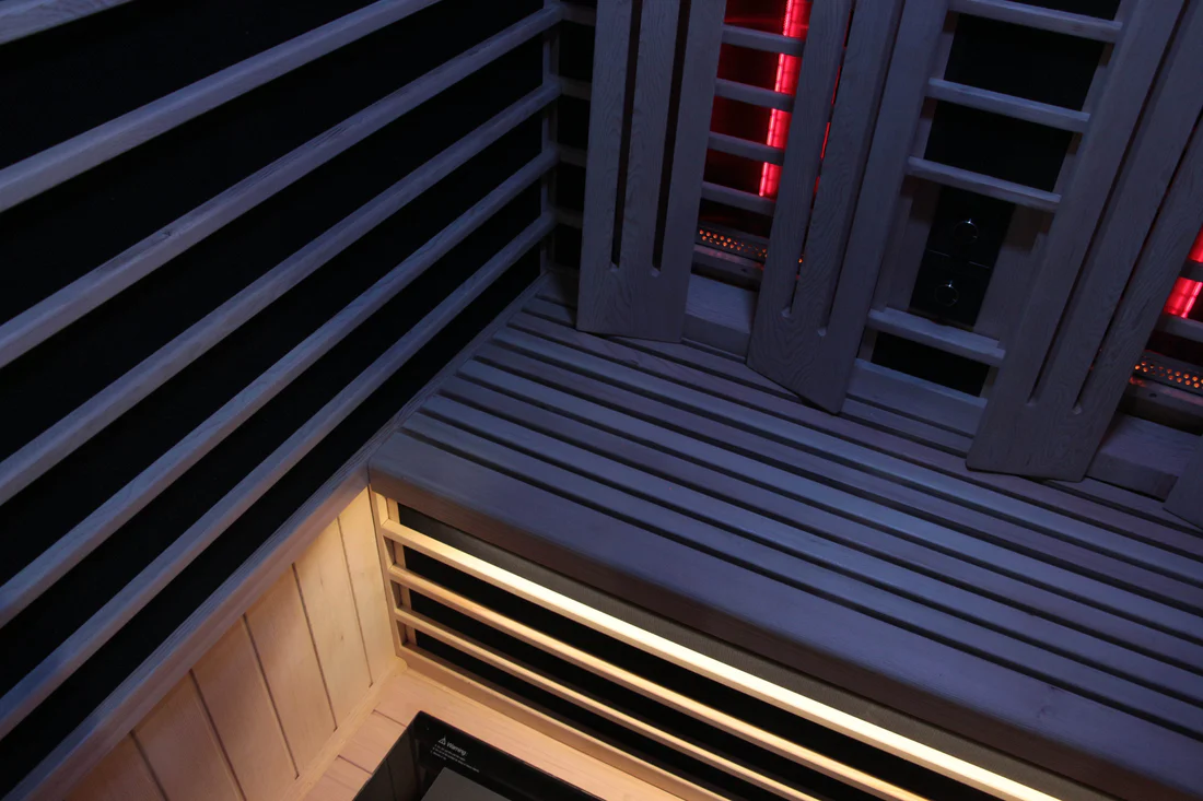Modern interior corner with black and white slatted walls and warm lighting.