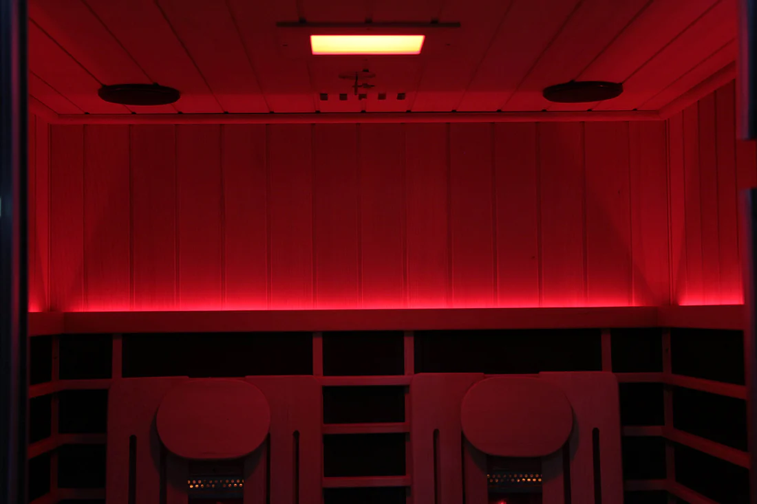 A dimly lit room with red ambient lighting and chairs.
