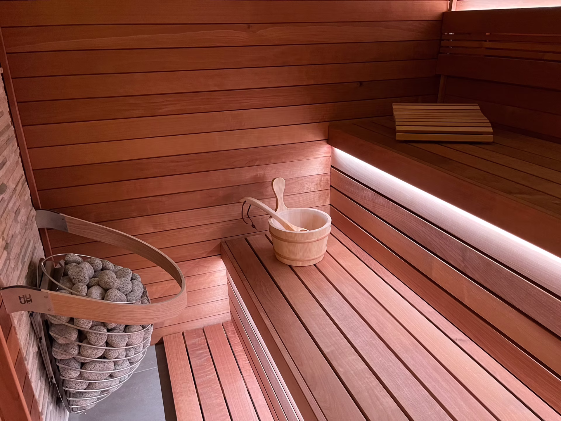 A cozy wooden sauna interior with a bucket and ladle.