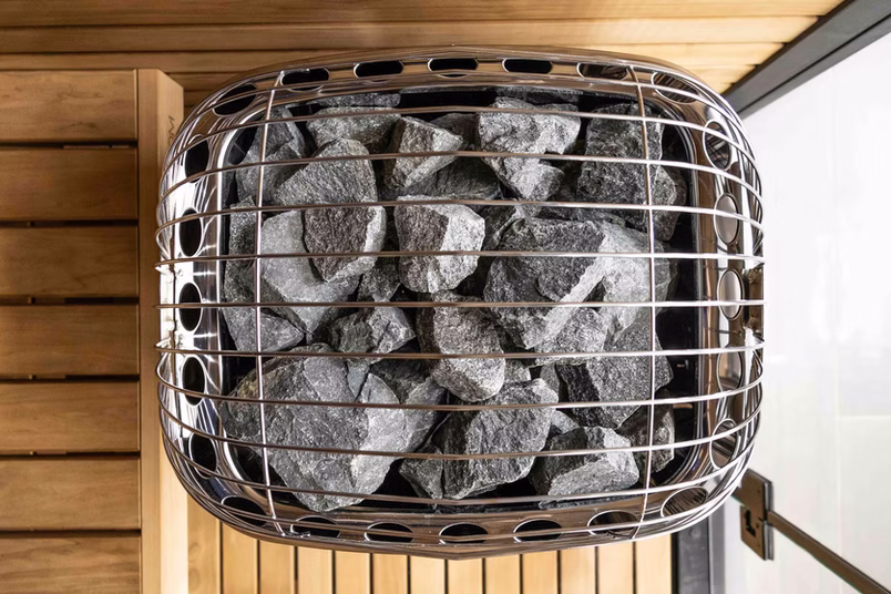 A metal grill with charcoal briquettes inside on a wooden surface.