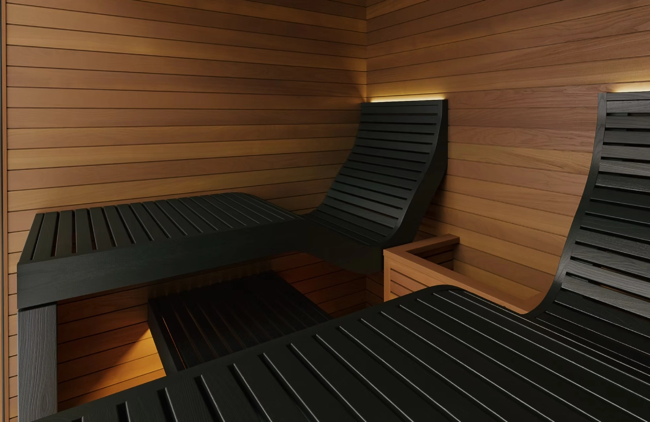 Cozy wooden sauna room with black cushioned loungers.