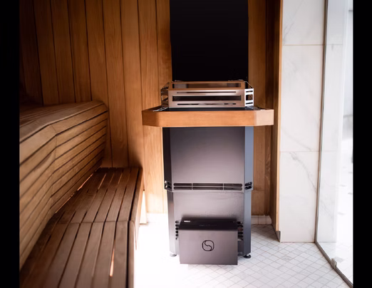 Cozy wooden sauna with a heater and audio system.