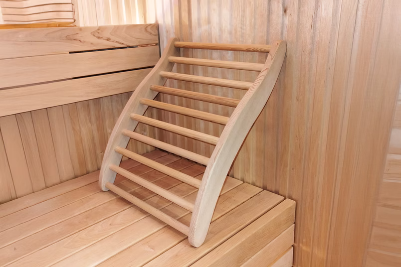 Curved wooden sauna footrest designed for comfort and relaxation.