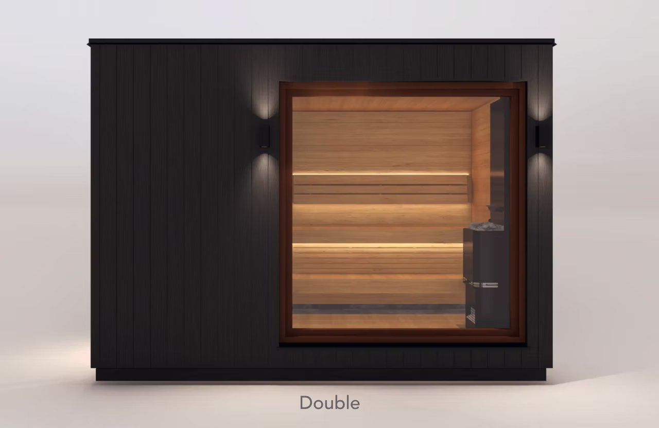 Modern wooden sauna with warm interior lighting and glass door.