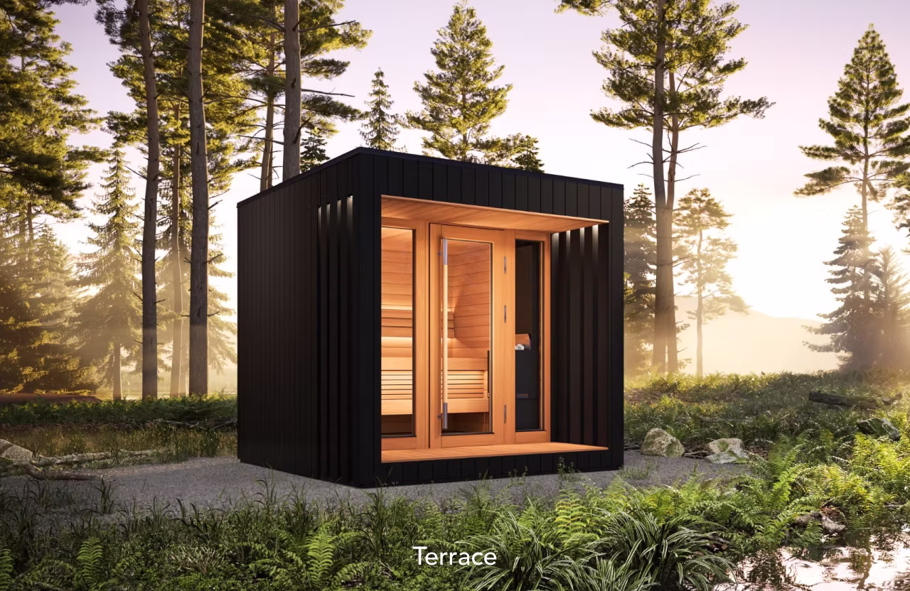 Modern black sauna cabin with warm wooden interior in a forest setting.