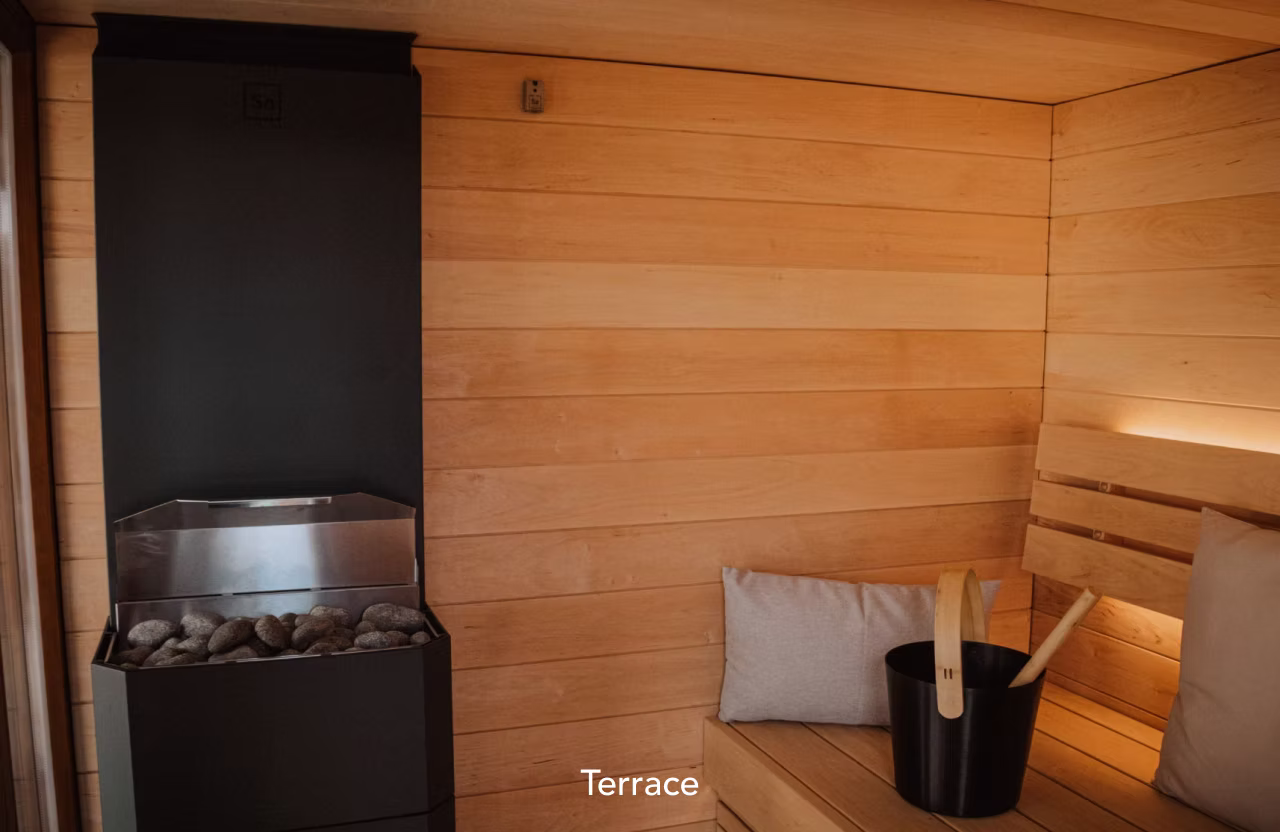 Cozy wooden terrace corner with cushioned seating and a bucket.