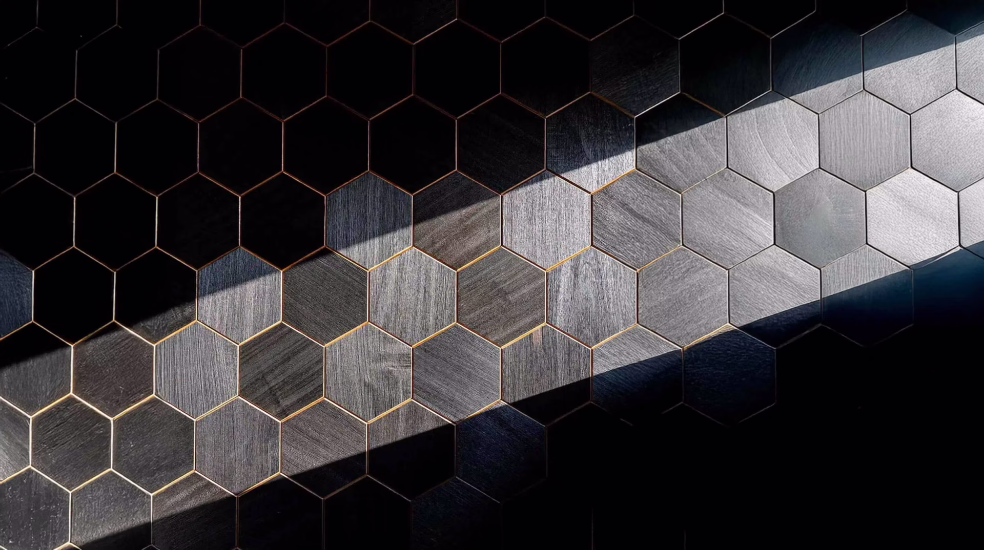 Hexagonal tiles in gradient shades from dark to light gray.