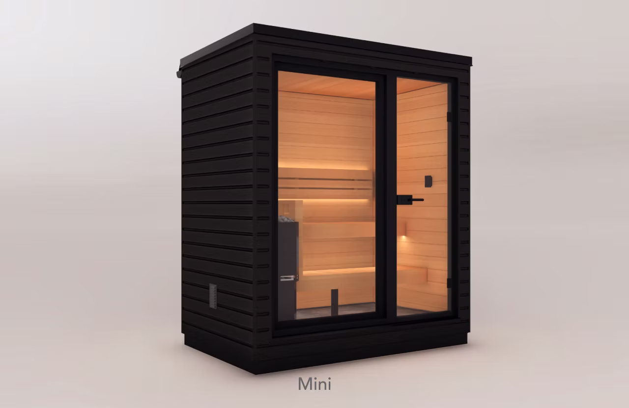 Compact black wooden sauna with glass door and warm interior lighting.